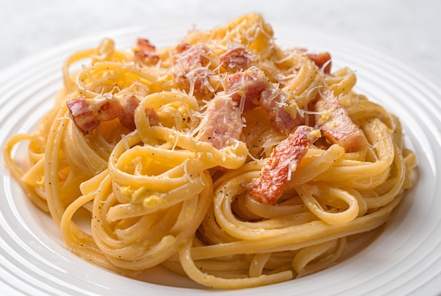 Pasta carbonara with bacon cheese cream and pepper closeup on a gray background Traditional Italian food