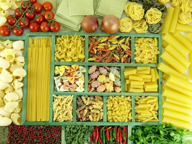 Pasta collection in wooden box and ingredients