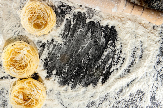 Pasta cooking ingredients on black kitchen table. Top view with space for your text