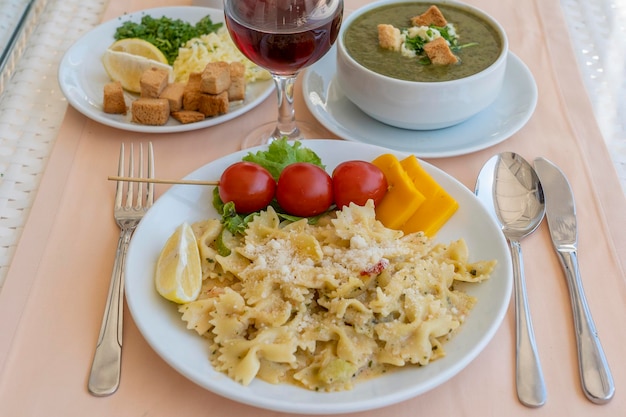 Pasta farfalle with cherry tomato and cheese in white plate closeup