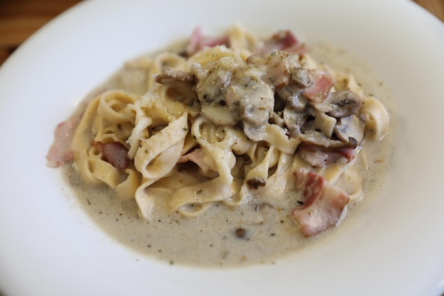 Pasta fettuccine alfredo white sauce with ham bacon and mushroom