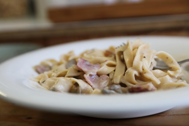 Pasta fettuccine alfredo white sauce with ham bacon and mushroom