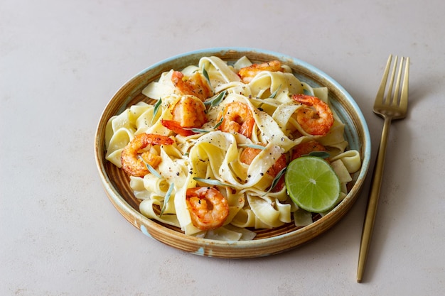 Pasta fettuccine in a creamy sauce with shrimp lime and sage Italian food