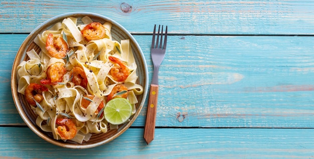 Pasta fettuccine in a creamy sauce with shrimp lime and sage Italian food