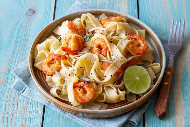 Pasta fettuccine in a creamy sauce with shrimp lime and sage Italian food