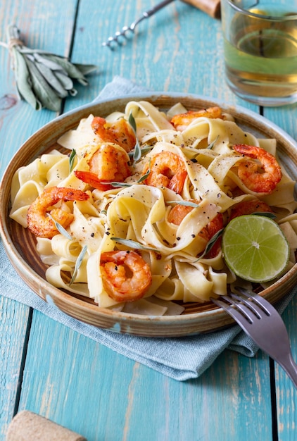 Pasta fettuccine in a creamy sauce with shrimp lime and sage Italian food