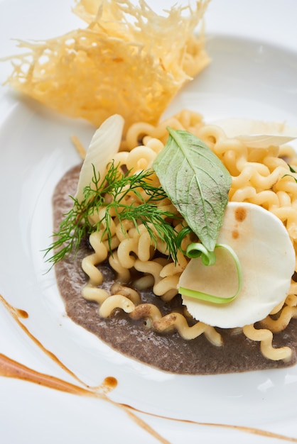 Pasta fusilli with mushroom sauce served on a white plate closeup