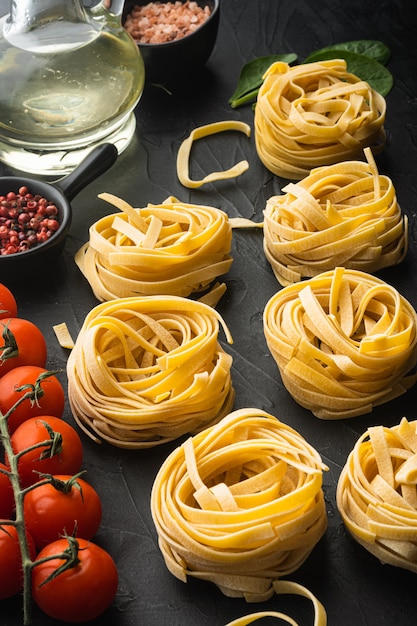 Pasta ingredients Tagliatelle with Italian food ingredients set, on black stone table