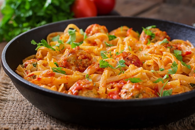 Pasta linguine with meatballs in tomato sauce.