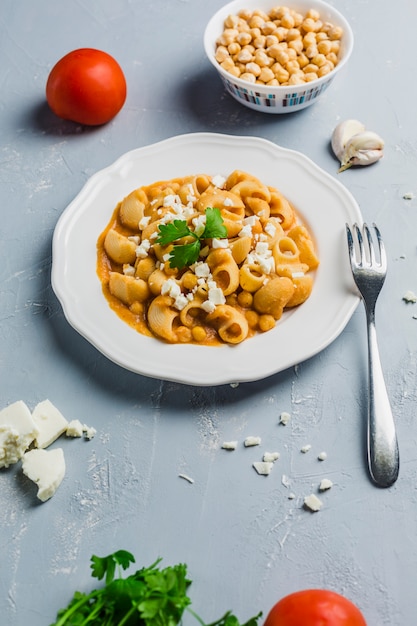 Pasta Pipa the rigat with a sauce of chickpeas and tomatoes, sprinkled with feta cheese and cilantro 