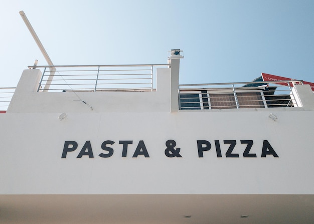 The pasta and pizza sign on old intentionally blurred house with balcony