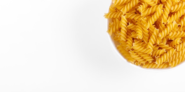 Pasta products in the form of a spiral on a plate texture on a white background