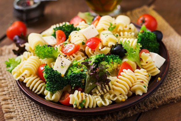 Pasta salad with tomato, broccoli, black olives,  and cheese feta