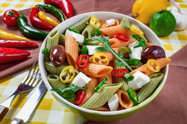 Pasta salad with tomatoarugula cucumber peppershot peppers black and green olives