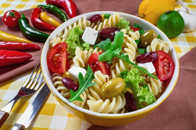 Pasta salad with tomatoarugula cucumber peppershot peppers black and green olives