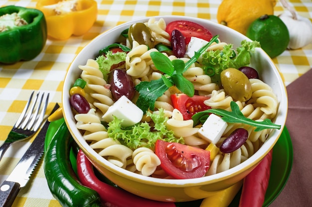 Pasta salad with tomatoarugula cucumber peppershot peppers black and green olives