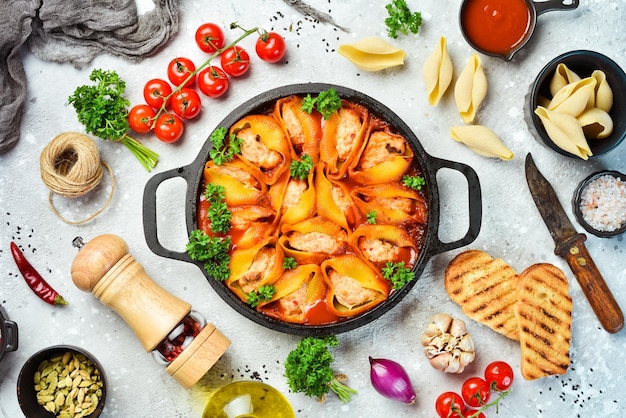 Pasta shells baked with meat tomatoes and parmesan In a frying pan Italian traditional cuisine Recipe