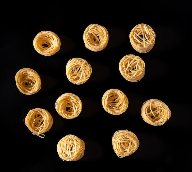 Pasta spaghetti on a black background top view flat lay