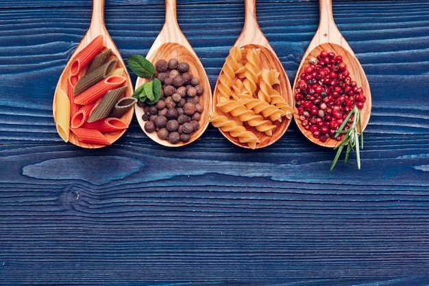 Pasta spaghetti, vegetables and spices, on wooden table