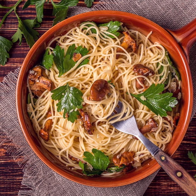 Pasta spaghetti with chanterelles mushrooms on wooden.