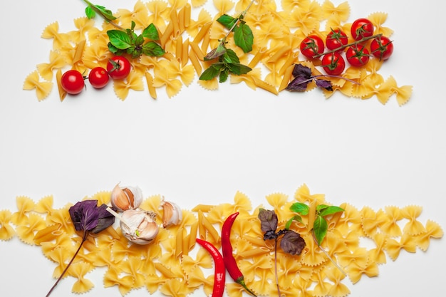 Pasta Spaghetti with ingredients for cooking pasta on a white background, top view.