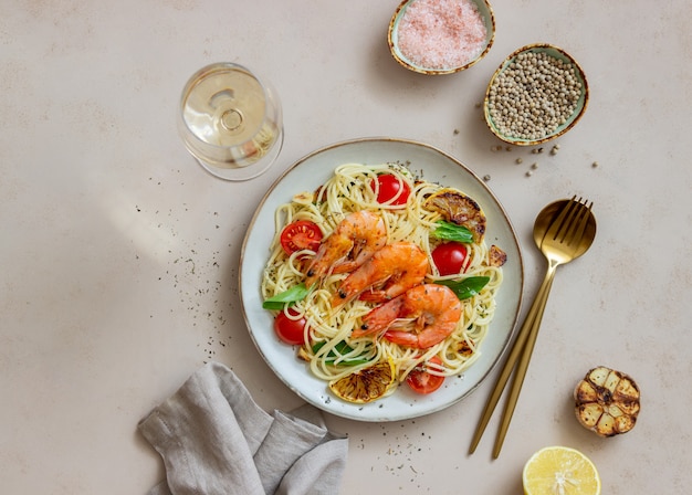 Pasta spaghetti with shrimp, tomatoes, garlic, spinach and lemon. Italian cuisine. Seafood. Diet.