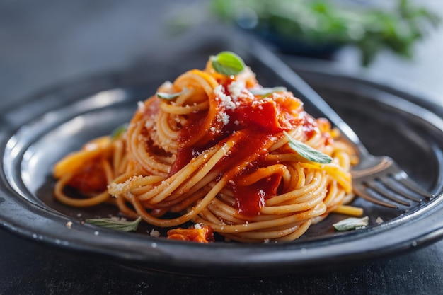 Pasta spaghetti with tomato sauce and cheese served on plate.