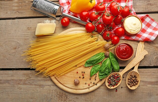 Photo pasta spaghetti with tomatoes cheese and basil on rustic wooden background