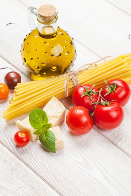 Pasta tomatoes basil on wooden table