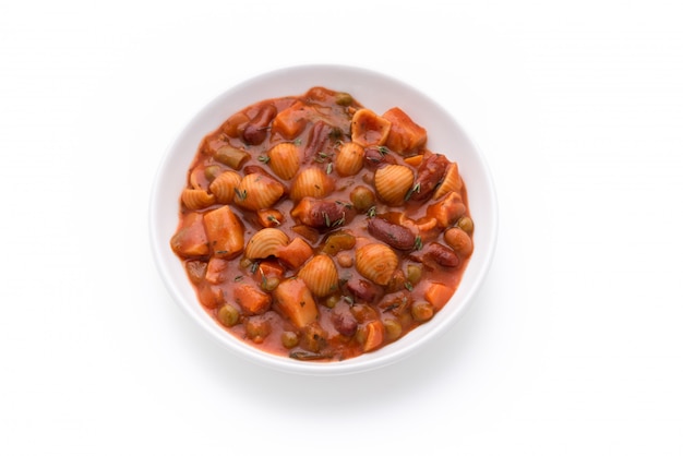 pasta vegetable grains peas soup in tomato sauce on isolated white background