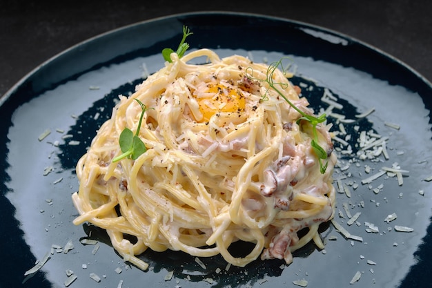 Pasta with bacon cheese microgreens and egg