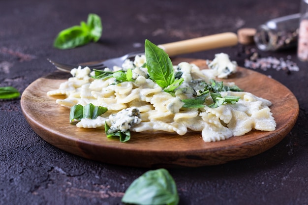 Pasta with creamy sauce with basil and gorgonzola cheese. 