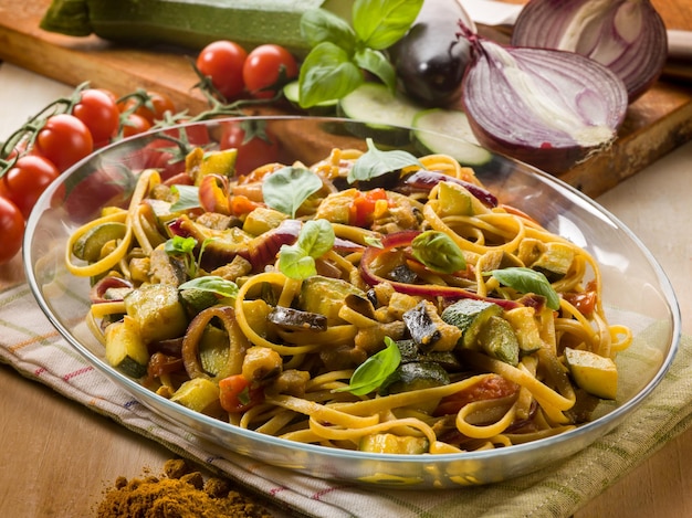 Pasta with eggplants zucchinis tomatoes and curry