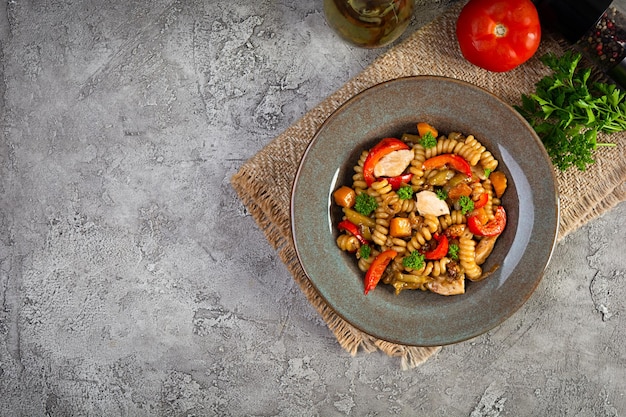 Pasta with fried chicken mushrooms pepper and pumpkin Top view