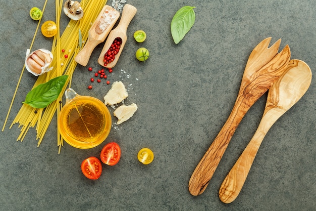 Pasta with ingredients on stone background .