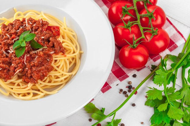 Pasta with meat, tomato sauce and vegetables on the table