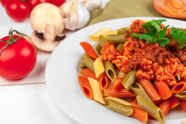 Photo pasta with meat, tomato sauce and vegetables on the table