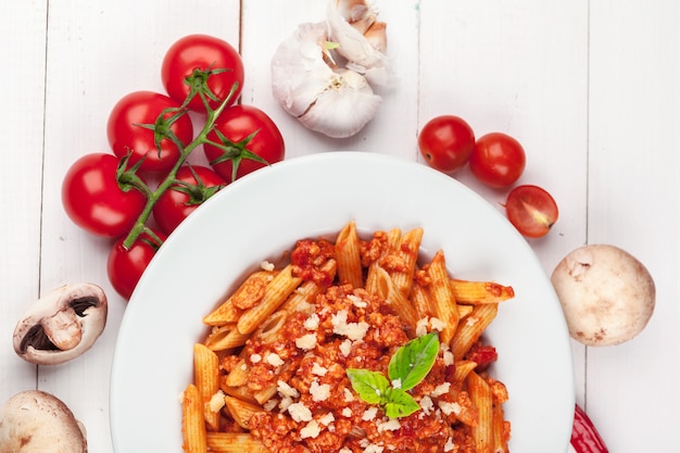 Pasta with meat, tomato sauce and vegetables on the table