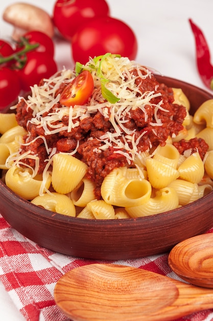 Pasta with meat, tomato sauce and vegetables on the table