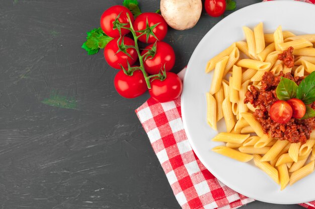 Pasta with meat, tomato sauce and vegetables on the table