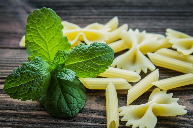 Pasta with mint on wooden background