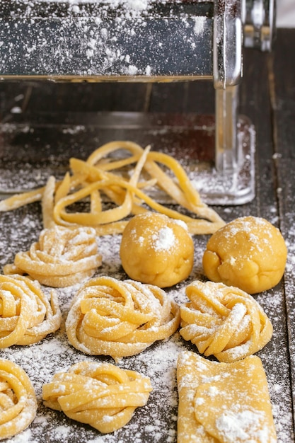 Pasta with pasta ingredients on the dark wooden table top view