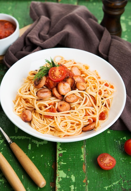 Pasta with sausages and tomato sauce on a rustic background, selective focus