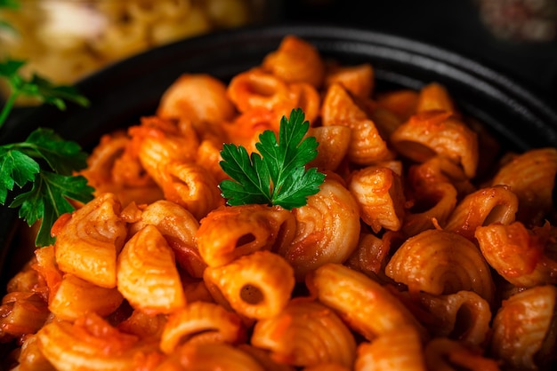 Pasta with tomato sauce on dark background. High quality photo