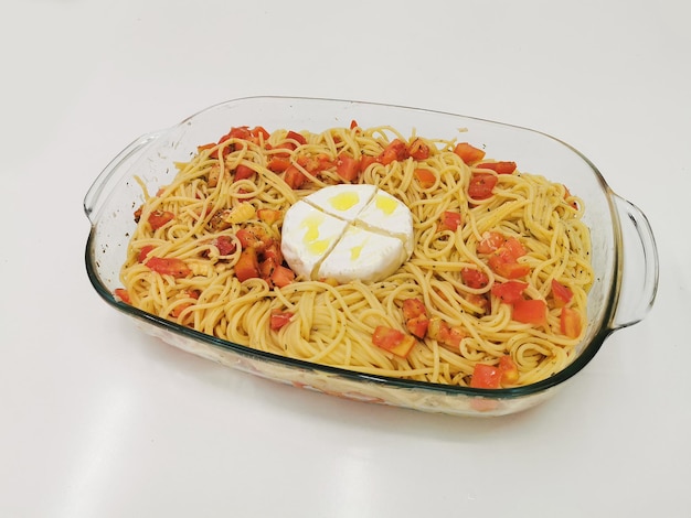 Pasta with tomatoes and camembert cheese on a white background Spaghetti