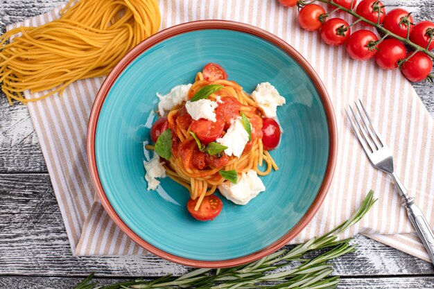 Pasta with tomatoes pasta on a white wooden background top view