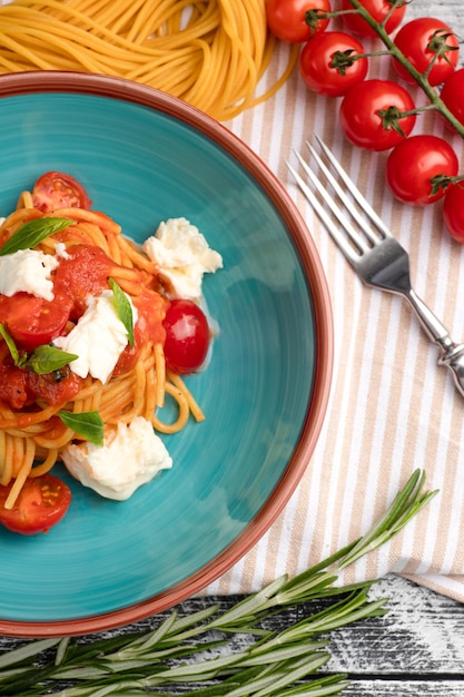 Pasta with tomatoes pasta on a white wooden background top view