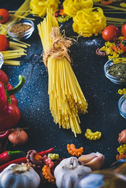 Pasta with vegetables cherry tomatoes chili peppers and garlic On a wooden background Free space for text Top view