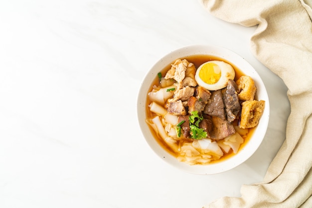 paste of rice flour or boiled Chinese pasta square with pork in brown soup - Asian food style