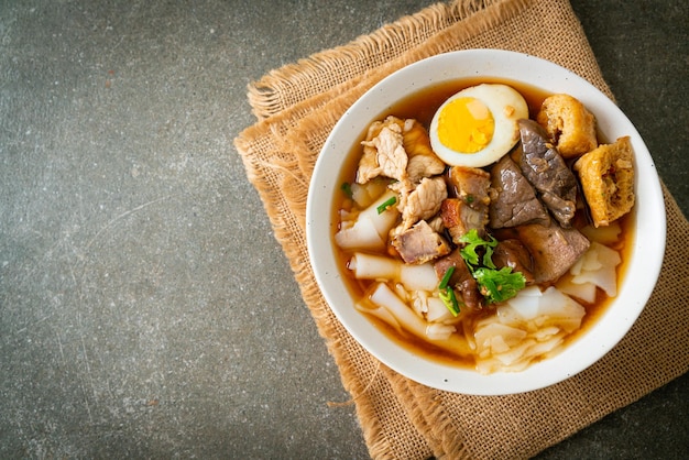 paste of rice flour or boiled Chinese pasta square with pork in brown soup - Asian food style